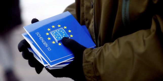 Estonian border guard holds booklets during the event to mark the 10th anniversary since Latvia and Estonia joined the Schengen area in bordertown Valga