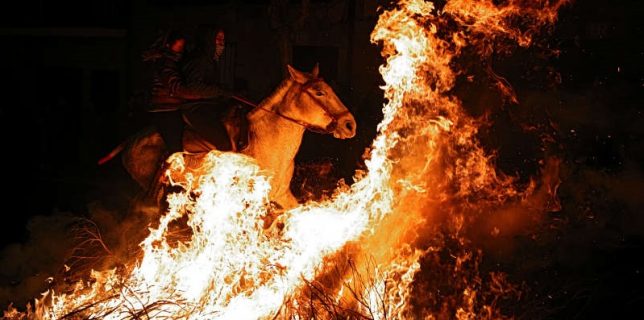 Two women ride a horse through flames during the annual „Luminarias” celebration on the eve of Saint Anthony’s day, Spain’s patron saint of animals, in the village of San Bartolome de Pinares, northwest of Madrid