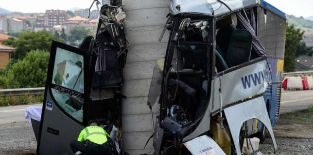 A civil guard surveys the wreckage of a bus crash which left at least four people dead in Aviles
